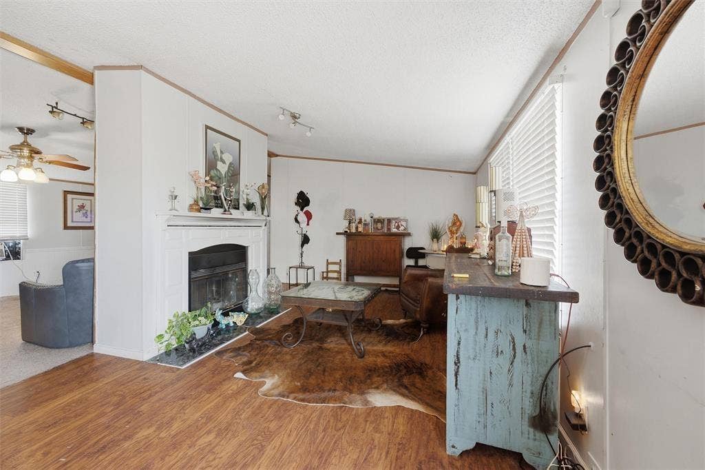866 Old Church Rd, Waxahachie, TX 75165 Wood-finish flooring, fireplace with a white mantel, stone-tile hearth, and track lighting