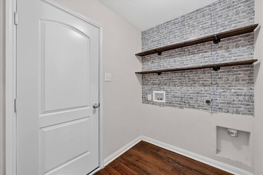 14276 Greenhaw Lane, Dallas, TX 75253 Utility area featuring wood-finish flooring, two open industrial-style floating shelves, and decorative faux-brick wall paneling