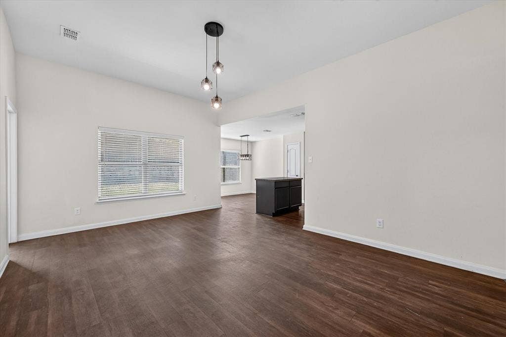 14276 Greenhaw Lane, Dallas, TX 75253 Interior space featuring high ceilings, wood-finish flooring, a multi-light pendant fixture, and large windows with horizontal blinds