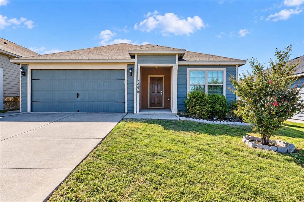 14276 Greenhaw Lane, Dallas, TX 75253 Single-story residence featuring blue horizontal lap siding, an attached two-car garage, an integrated front entry porch, and a concrete driveway