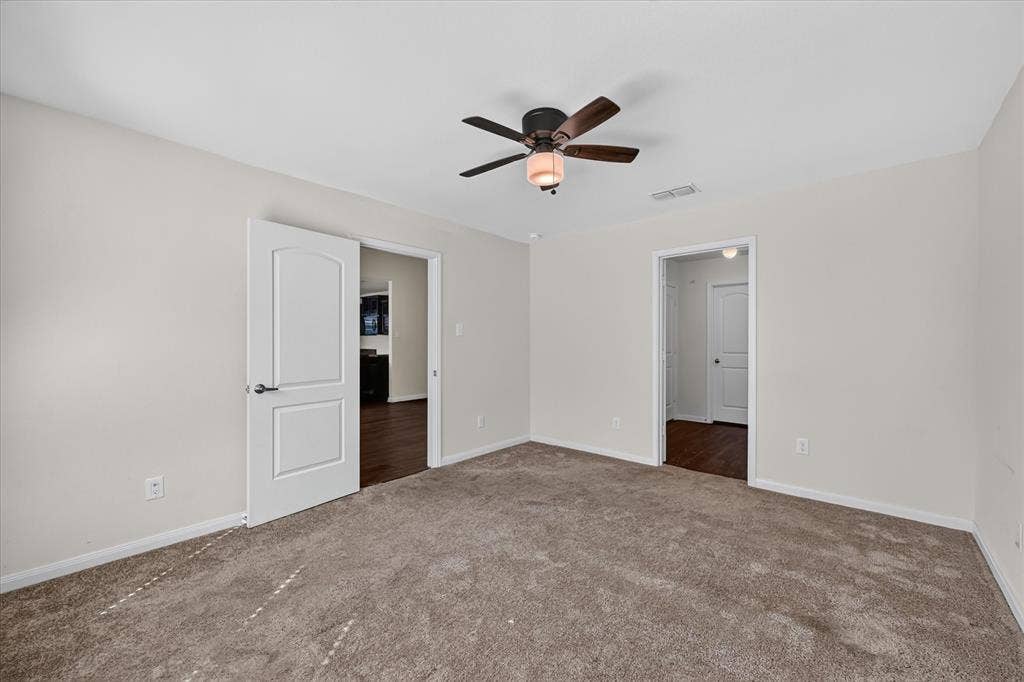 14276 Greenhaw Lane, Dallas, TX 75253 Interior space featuring neutral wall tones, plush wall-to-wall carpeting, a multi-blade ceiling fan with a centered light fixture, and arched-panel interior doors