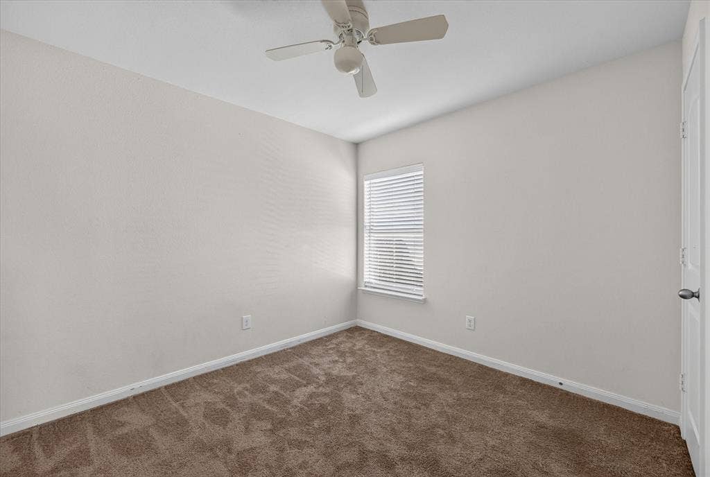 14276 Greenhaw Lane, Dallas, TX 75253 Neutral-toned interior space featuring neutral wall-to-wall carpeting, a multi-blade ceiling fan, and a single window with horizontal blinds