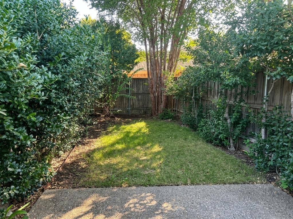 6011 Highplace Circle, Dallas, TX 75254 Rear yard featuring a concrete patio, perimeter wood fencing, and mature landscaping