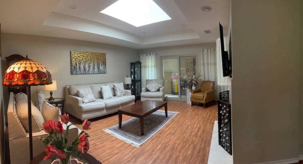 6011 Highplace Circle, Dallas, TX 75254 Tray ceiling featuring a central skylight, wood-finish flooring, sliding glass doors, and a fireplace surround