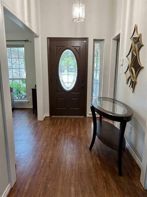 6011 Highplace Circle, Dallas, TX 75254 Foyer featuring wood-finish flooring, a solid-core entry door with an oval glass insert, an elongated vertical sidelight, and a hanging geometric lantern pendant fixture