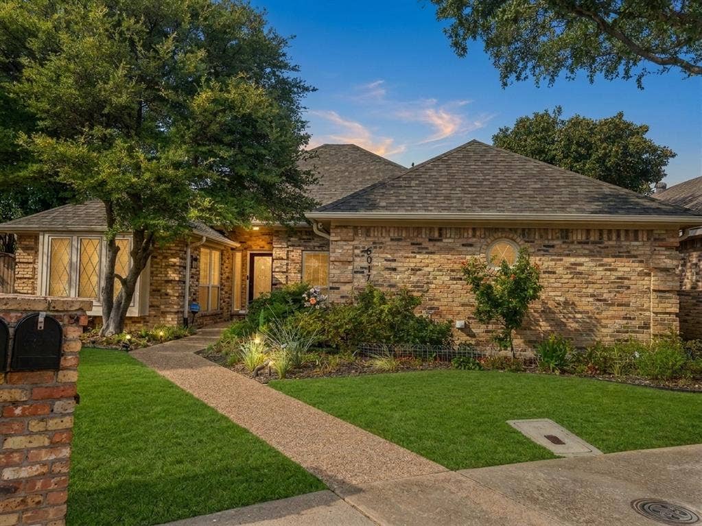 6011 Highplace Circle, Dallas, TX 75254 Brick exterior facade featuring a multi-gabled roofline, diamond-patterned window panes, a decorative circular accent window, and a finished masonry mailbox