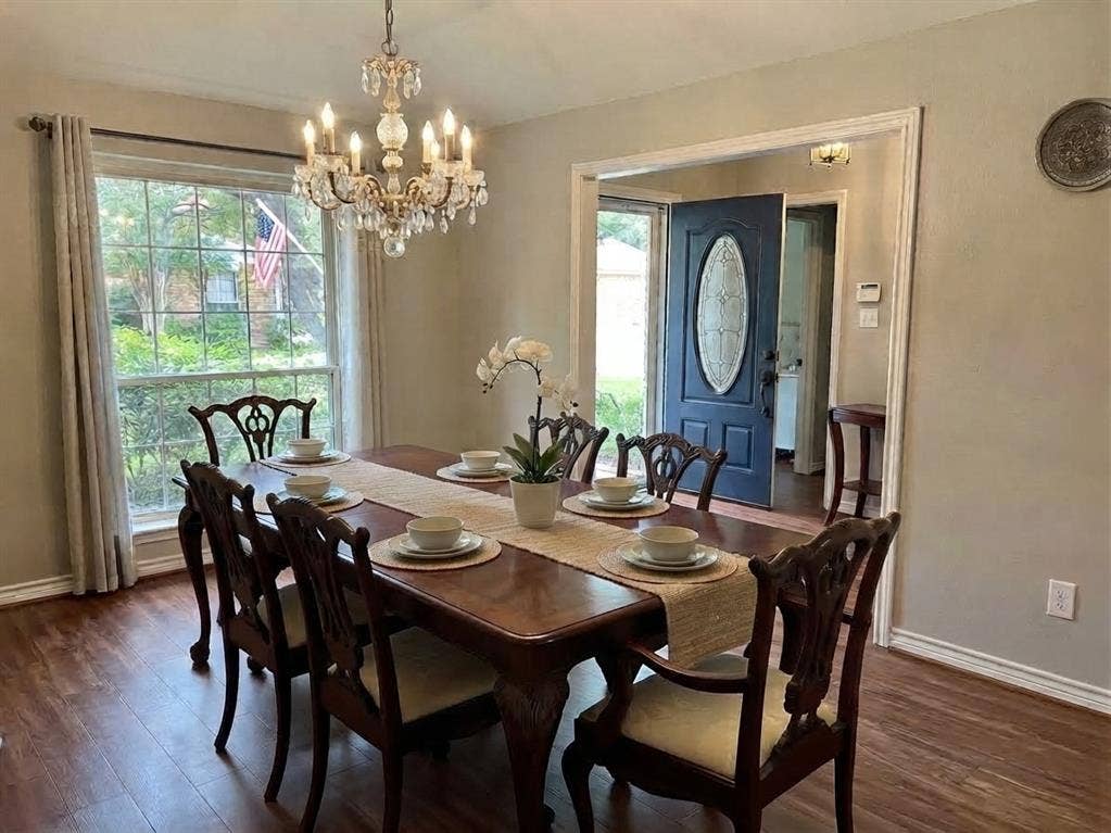 6011 Highplace Circle, Dallas, TX 75254 Dining area featuring wood-finish flooring, a multi-light crystal chandelier, a large multi-pane window, and an entry door with an oval glass insert