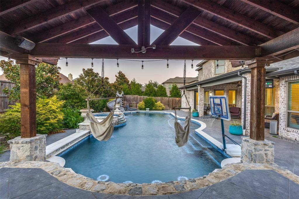 Pool at dusk featuring a fenced backyard, a patio area, a ceiling fan, and a gazebo