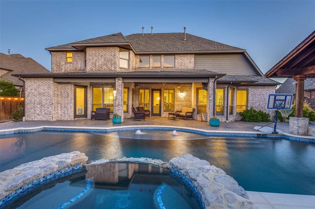 View of swimming pool featuring a pool with connected hot tub and a patio