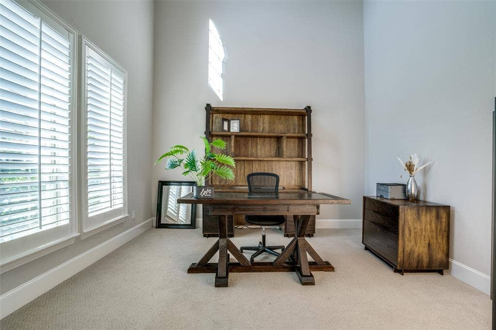 Office featuring soaring 2 story ceiling and double doors