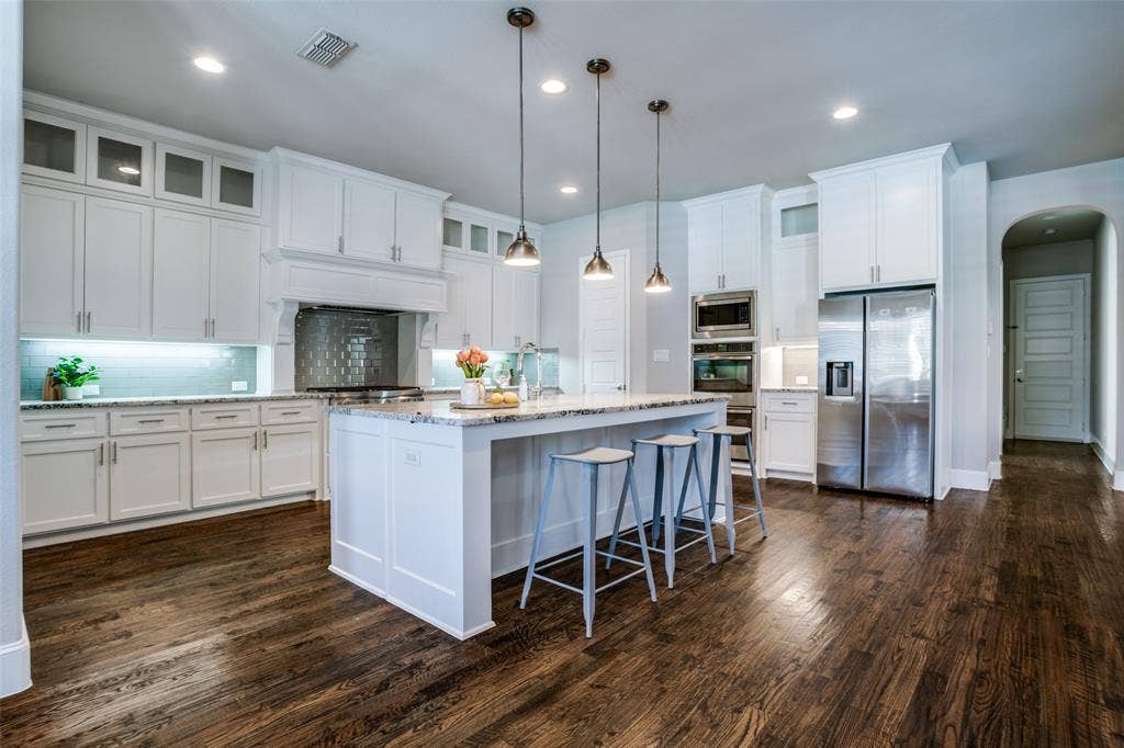 Kitchen featuring pendant lights over island and tall cabinets