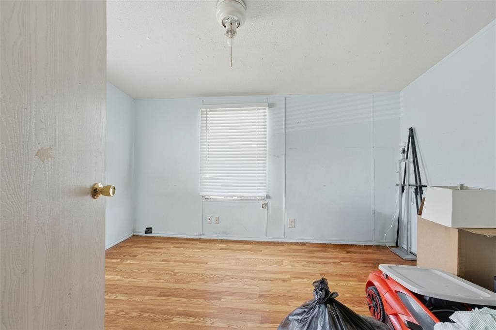 902 Old Church Rd, Waxahachie, TX 75165 Room featuring wood-finish flooring, a central ceiling-mounted light fixture, and a window equipped with horizontal blinds