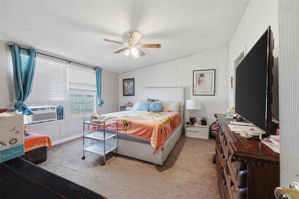 902 Old Church Rd, Waxahachie, TX 75165 Bedroom with neutral wall paneling, carpeting, integrated ceiling fan with light fixture, and horizontal window blinds