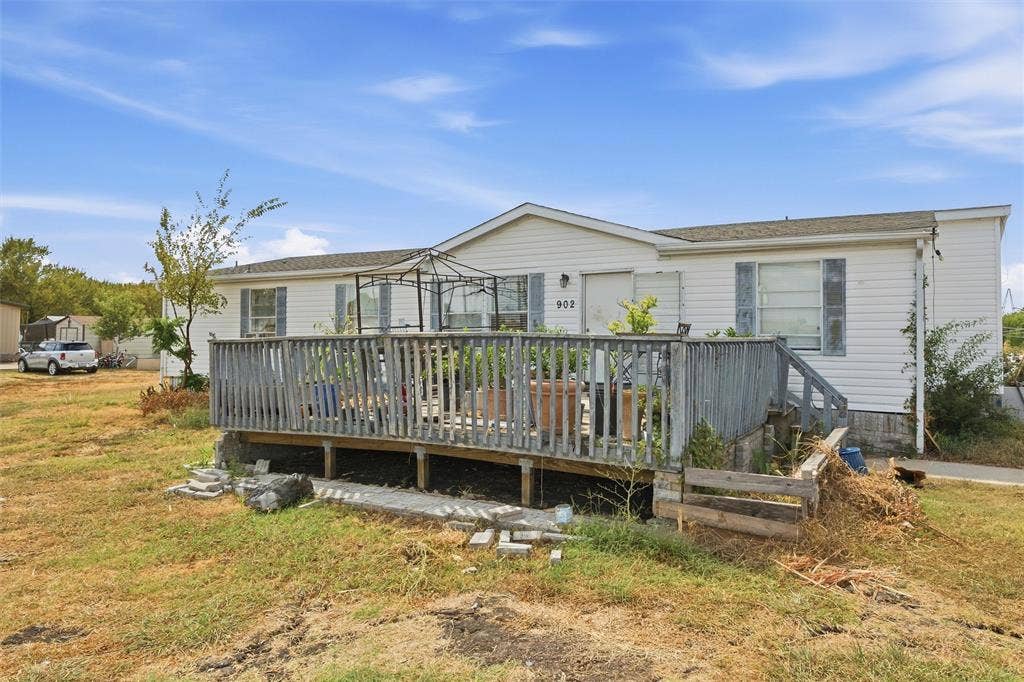 902 Old Church Rd, Waxahachie, TX 75165 Single-story exterior featuring horizontal siding, a raised wood deck with balustrades, and window shutters