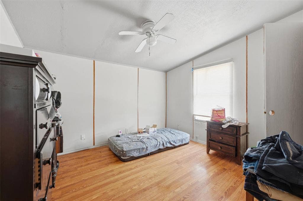 902 Old Church Rd, Waxahachie, TX 75165 Interior room featuring wood-finish flooring, white paneled walls, and a white ceiling fan with integrated lighting