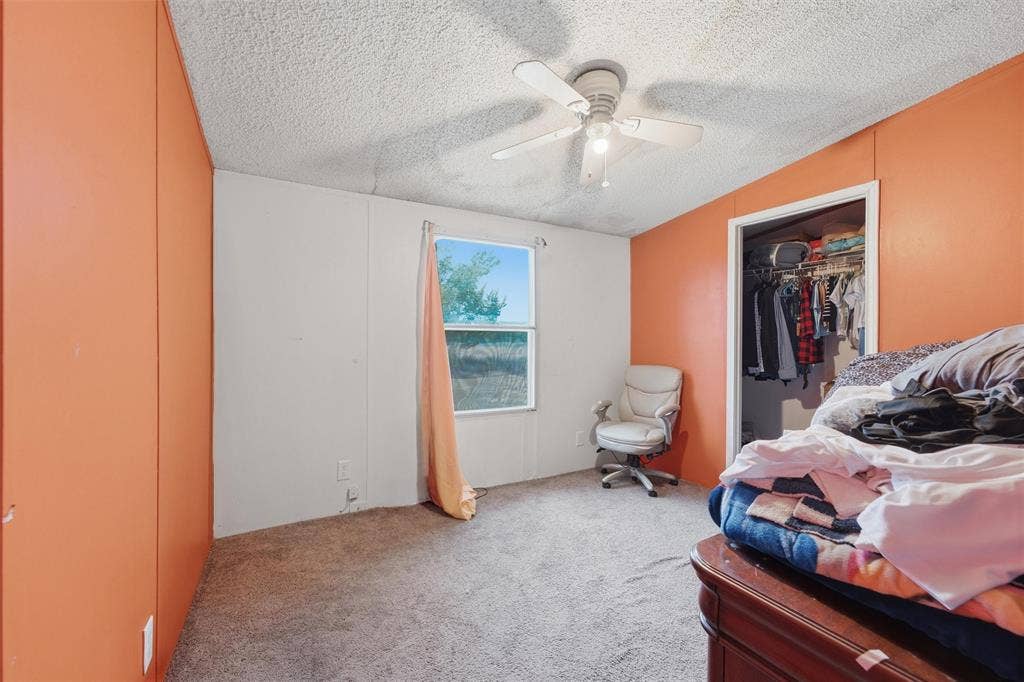 902 Old Church Rd, Waxahachie, TX 75165 Textured ceiling with a central multi-blade ceiling fan, wall-to-wall carpeting, single-hung window, and a built-in reach-in closet