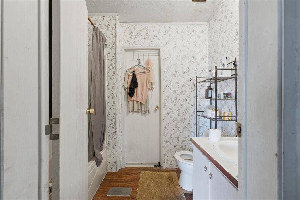 902 Old Church Rd, Waxahachie, TX 75165 Bathroom featuring a white vanity cabinet, a drop-in sink, a shower and tub combination, and wood-finish flooring