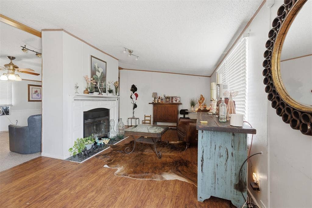 902 Old Church Rd, Waxahachie, TX 75165 Living space featuring wood-finish flooring, a fireplace with a white mantel, and horizontal window blinds