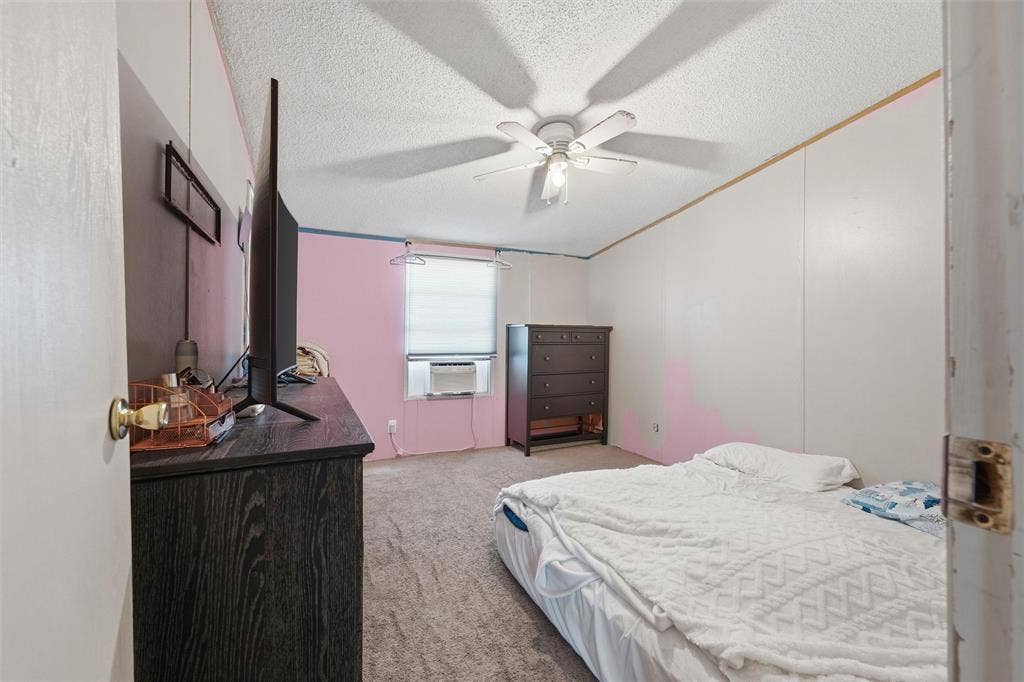 902 Old Church Rd, Waxahachie, TX 75165 Room featuring wall-to-wall carpeting, a ceiling-mounted fan with integrated lighting, and a window with a mounted window air conditioning unit