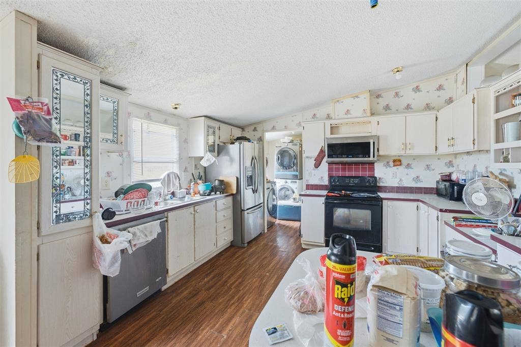 902 Old Church Rd, Waxahachie, TX 75165 Kitchen featuring wood-finish flooring, white cabinetry, built-in glass-front display cabinetry, and stainless steel appliances including a refrigerator, dishwasher, and microwave