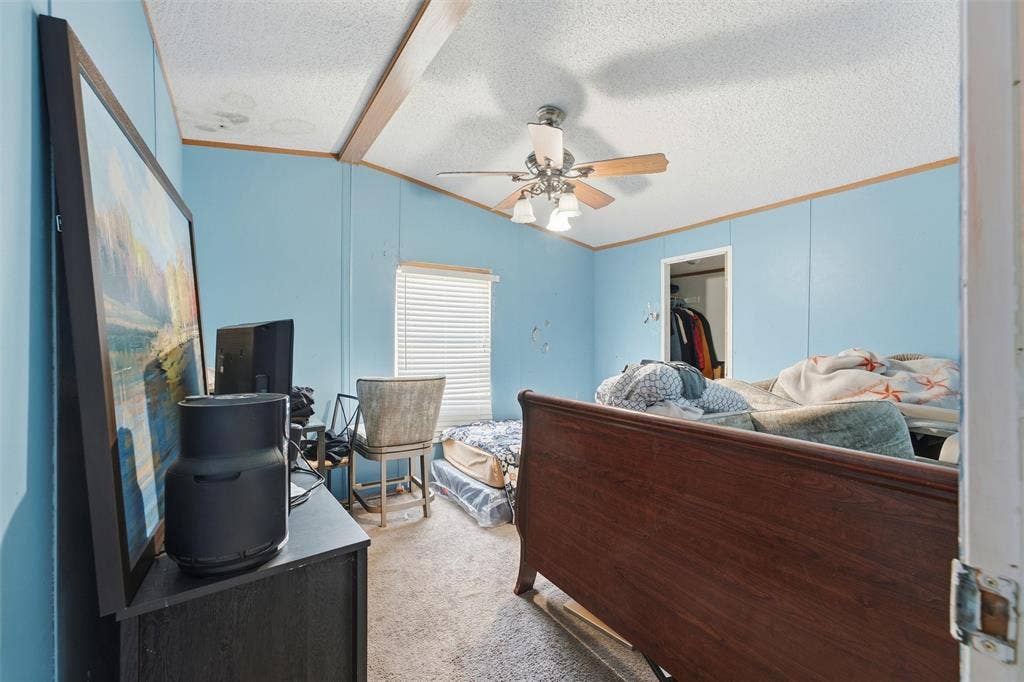 902 Old Church Rd, Waxahachie, TX 75165 Vaulted ceiling featuring a central support beam and a multi-light ceiling fan with wood-tone blades, paired with horizontal window blinds