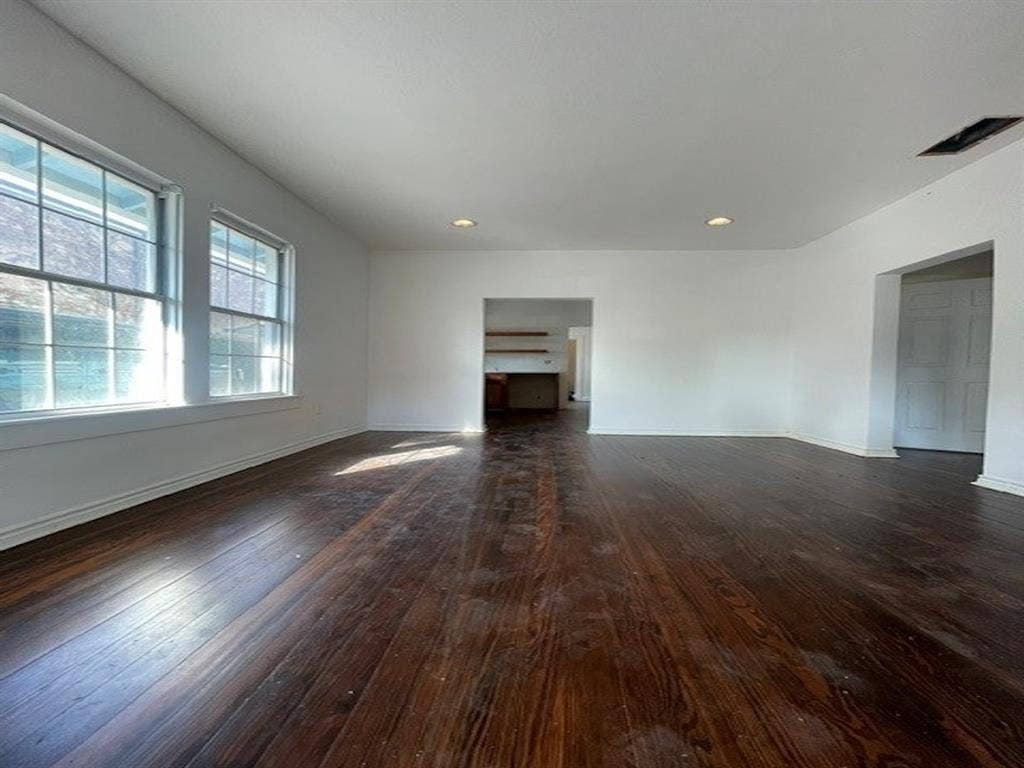 422 S Glasgow Drive, Dallas, TX 75223 Expansive room featuring rich wood-finish flooring, multiple windows, recessed lighting, and a neutral color palette