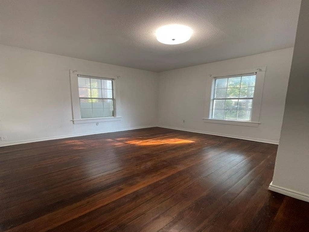 422 S Glasgow Drive, Dallas, TX 75223 Expansive room featuring dark wood-finish flooring, two large windows, and a flush mount ceiling light