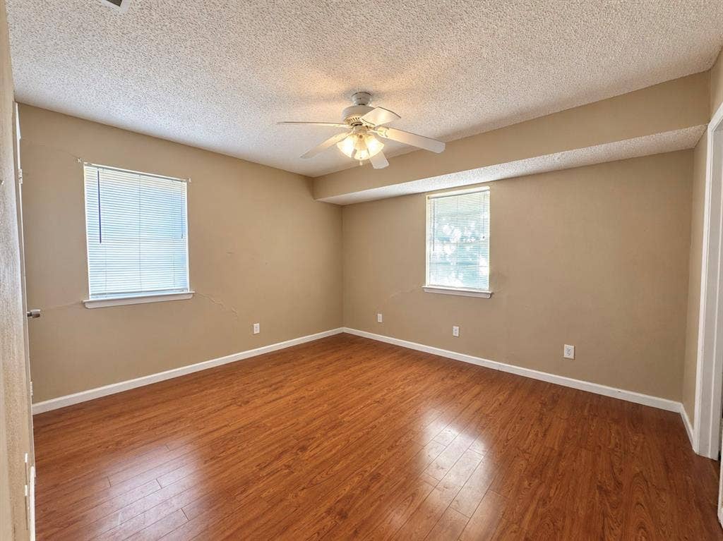 2418 Fulton Drive, Mesquite, TX 75150 Wood-finish flooring, two windows with integrated blinds, and a ceiling-mounted light fixture with fan