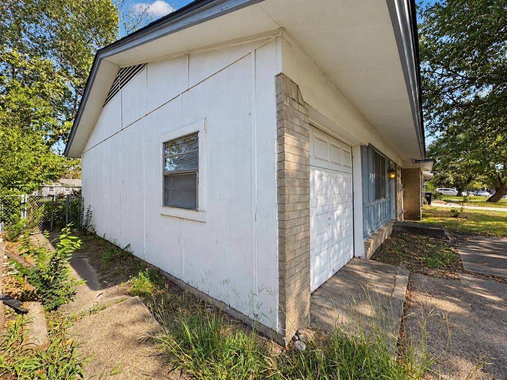 2418 Fulton Drive, Mesquite, TX 75150 Exterior view featuring white panel siding, brick masonry accent, single-car garage door, and concrete driveway