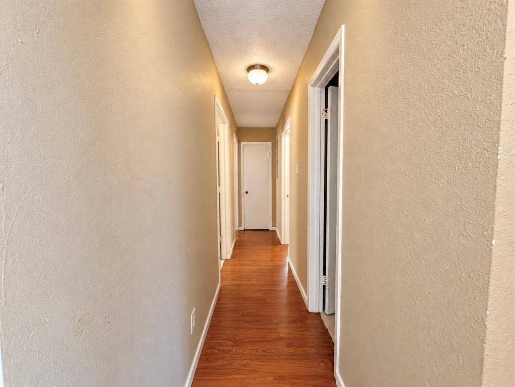 2418 Fulton Drive, Mesquite, TX 75150 Hallway featuring wood-finish flooring, textured walls, and a flush-mount ceiling light fixture