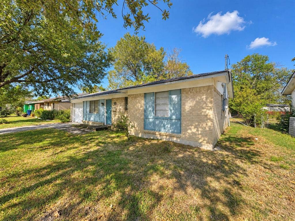 2418 Fulton Drive, Mesquite, TX 75150 Single-story brick exterior featuring a hip roof, metal window shutters, and a concrete driveway