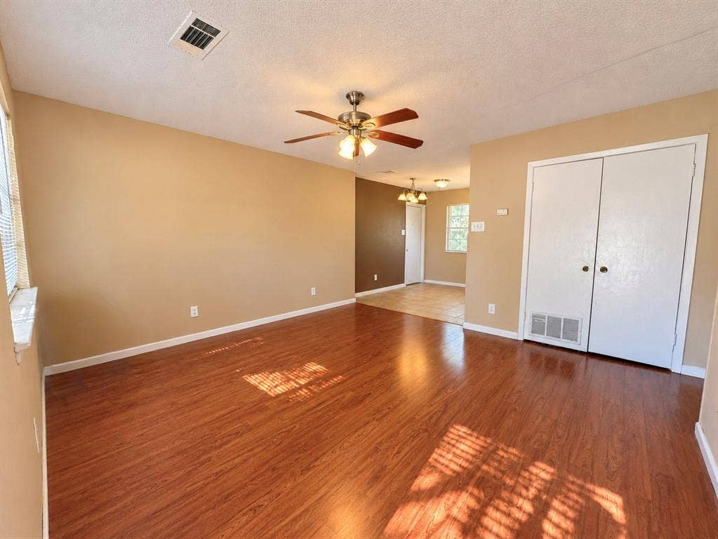 2418 Fulton Drive, Mesquite, TX 75150 Interior room featuring wood-finish flooring, a ceiling-mounted light fixture with a central fan, and double-door closet cabinetry