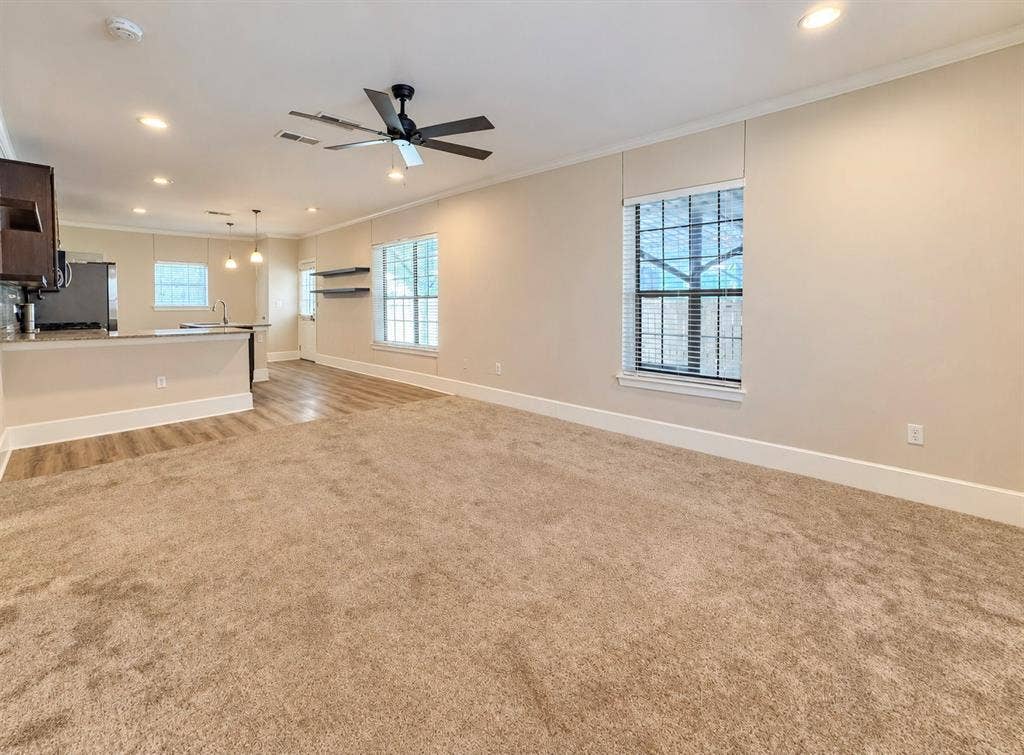 4227 Delano Place, Dallas, TX 75204 Open floor plan featuring neutral carpeting, recessed lighting, a modern ceiling fan, wood-finish flooring, and multi-pane windows