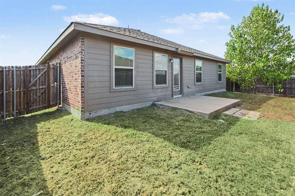 814 Rustic Meadows Trail, Princeton, TX 75407 Rear exterior featuring brick and horizontal siding, concrete patio, and wood privacy fencing