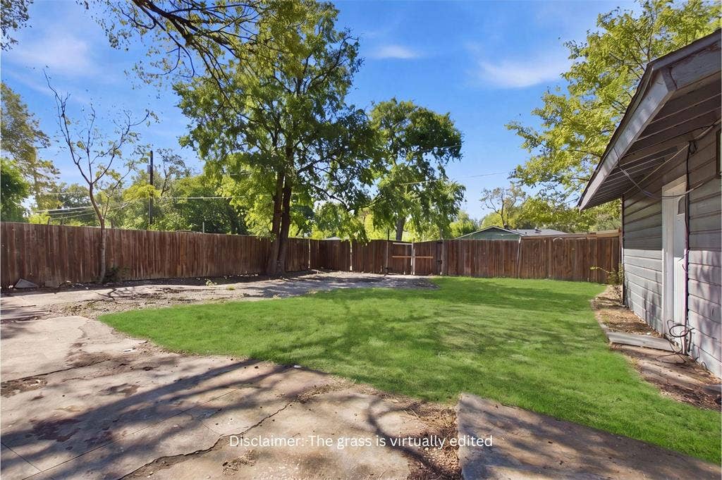 2009 S 1st Street, Garland, TX 75041 Backyard featuring a grass lawn, expansive concrete patio, horizontal wood fencing, and mature trees