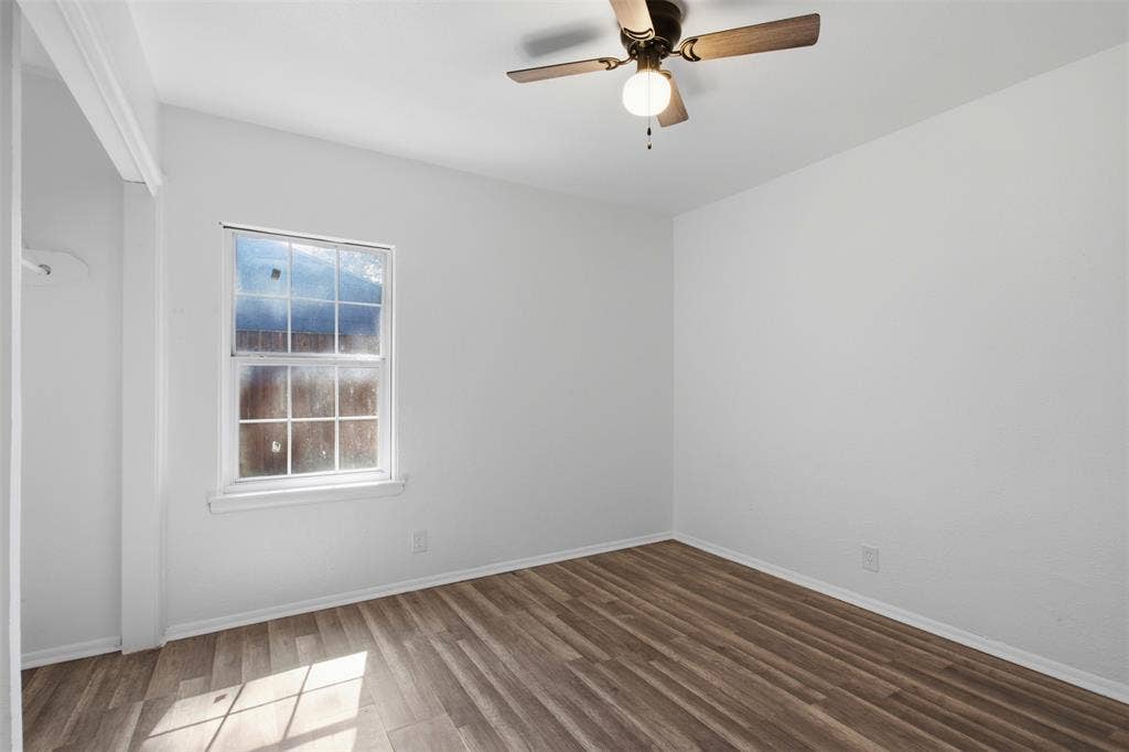 2009 S 1st Street, Garland, TX 75041 Wood-finish flooring, single-hung window with decorative muntins, and a ceiling-mounted light fixture with fan blades