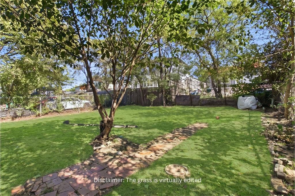 2009 S 1st Street, Garland, TX 75041 Expansive backyard featuring a lush lawn, mature trees, and a brick-paver pathway