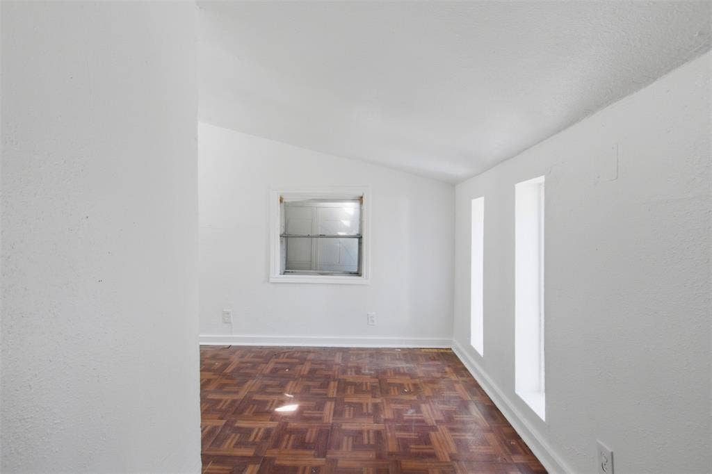 2009 S 1st Street, Garland, TX 75041 Parquet wood-finish flooring, vaulted ceiling, and multiple window placements