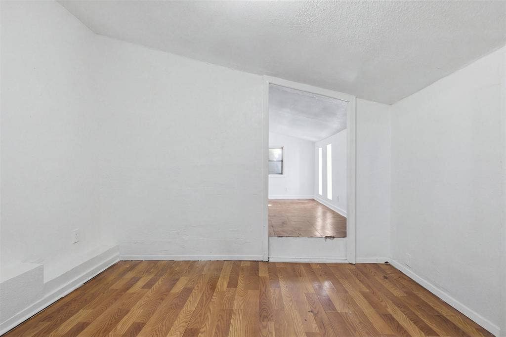 2009 S 1st Street, Garland, TX 75041 Interior space featuring wood-finish flooring, white walls, and a recessed ceiling design with a wide open-entry portal
