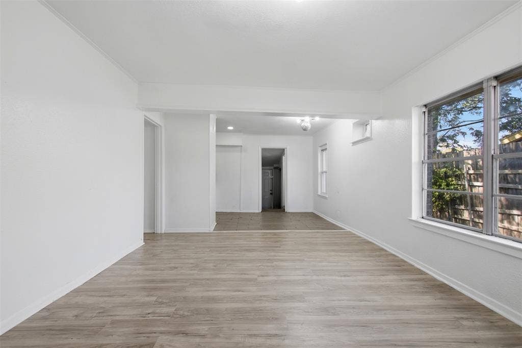 2009 S 1st Street, Garland, TX 75041 Interior space featuring wood-finish flooring, white walls, large multi-pane windows, and recessed lighting