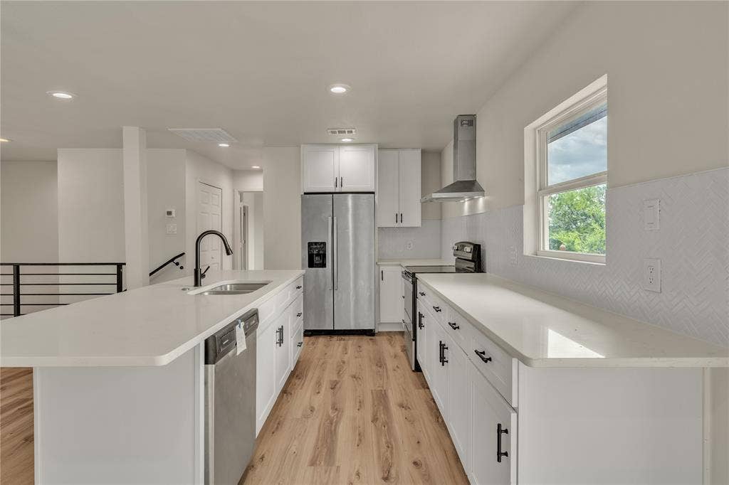 1719 Boot Hill Road, Granbury, TX 76049 Kitchen featuring white cabinetry, quartz countertops, wood-finish flooring, a stainless steel range hood, and a herringbone-pattern backsplash