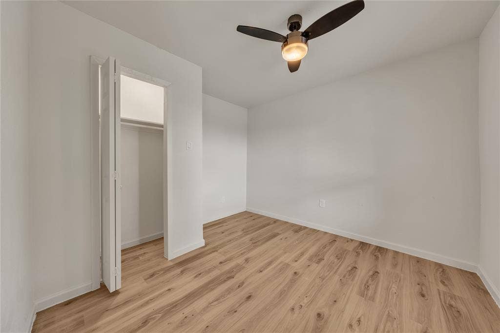 1719 Boot Hill Road, Granbury, TX 76049 Interior room featuring wood-finish flooring, a bi-fold closet, and a multi-blade ceiling fan with integrated lighting