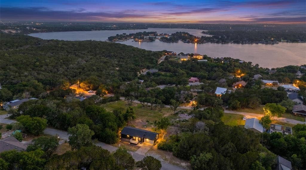 1719 Boot Hill Road, Granbury, TX 76049 Aerial perspective of a single-story residence situated on a treed lot with proximity to a large lake
