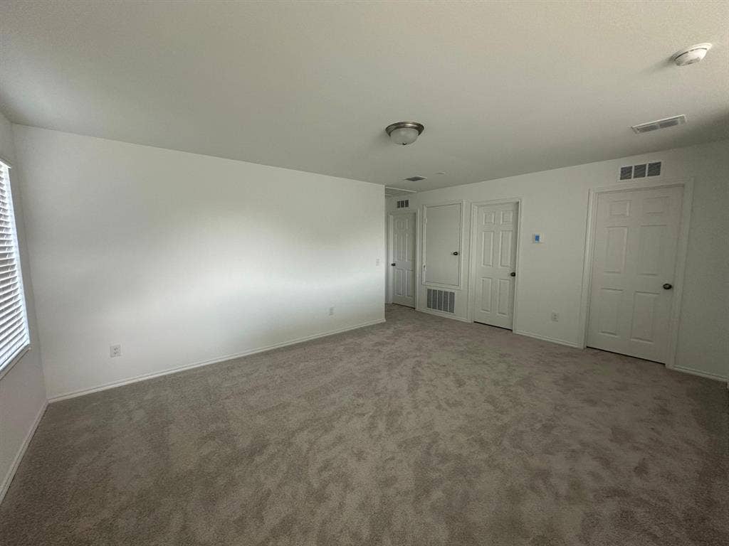 821 POPPY COVE Lane, Princeton, TX 75407 Neutral-toned wall-to-wall carpeting, white interior walls, and multiple paneled doors