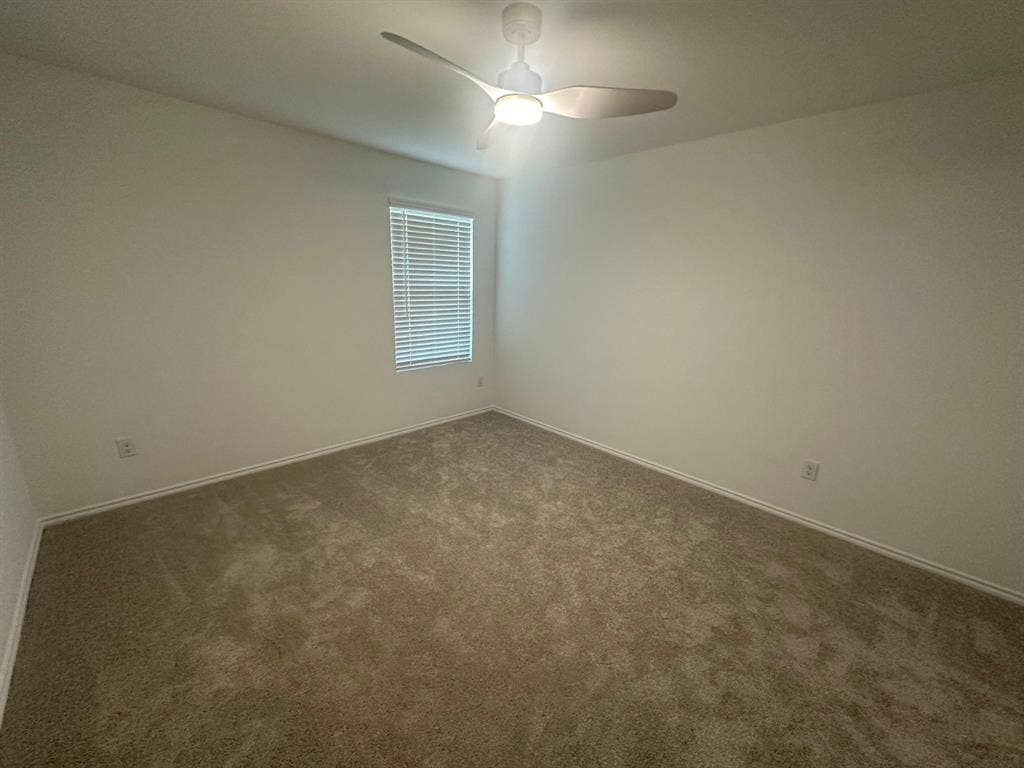 821 POPPY COVE Lane, Princeton, TX 75407 Room featuring neutral-toned carpeting, a modern ceiling fan with integrated lighting, and a window equipped with horizontal blinds