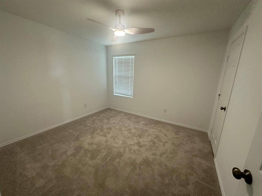821 POPPY COVE Lane, Princeton, TX 75407 Neutral-toned carpeted flooring, wall-mounted ceiling fan with integrated lighting, single-pane window with horizontal blinds, and paneled closet door