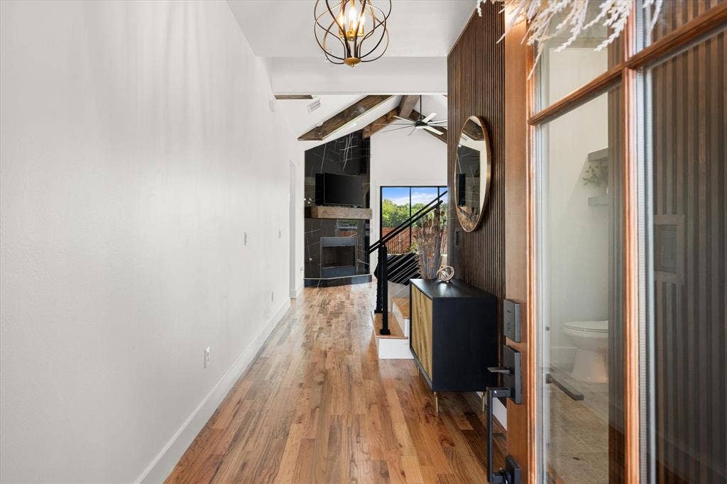 122 Yvonne Street, Red Oak, TX 75154 Entryway featuring oak wood flooring, vaulted ceilings with wood beams, a fireplace with black tile ......