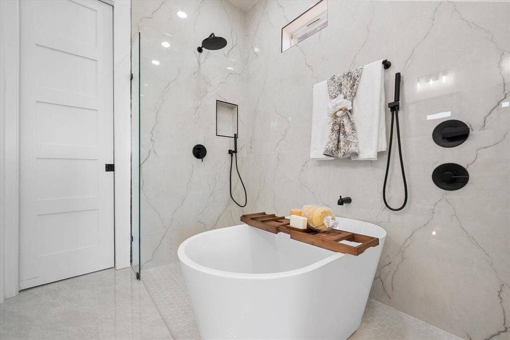 122 Yvonne Street, Red Oak, TX 75154 Primary bathroom 1- ensuite bathroom with a wet area that includes dual rainfall shower heads, a freestanding soaking tub with matte black hardware, floor-to-ceiling tile wall, glass-enclosed shower, built-in recessed niches