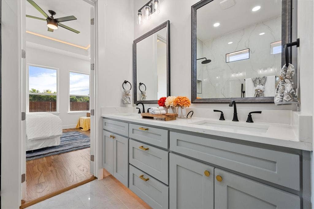 122 Yvonne Street, Red Oak, TX 75154 Dual-sink vanity with quartz countertops, matte black plumbing fixtures, and framed mirrors
