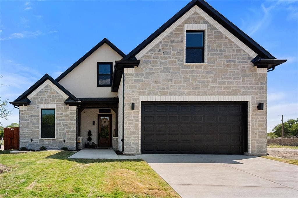 122 Yvonne Street, Red Oak, TX 75154 Exterior featuring stone, stucco and brick with a multi-gabled roofline, extra wide concrete driveway, and attached two-car garage